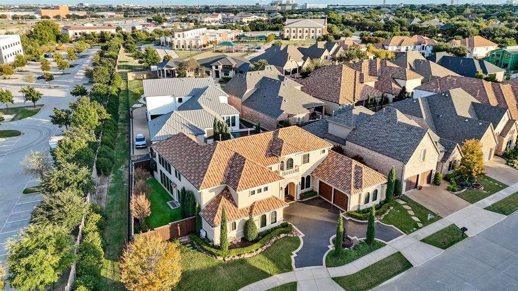 6590 Gerrard Street, Frisco, TX 75034 Two-story residential structure featuring a clay tile roof, arched entryway, upper-level balcony, and attached multi-car garage with a paved driveway