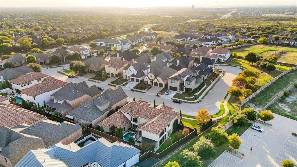 6590 Gerrard Street, Frisco, TX 75034 Aerial perspective of a suburban neighborhood featuring residential homes, multi-gabled rooflines, stone and stucco facades, and a private swimming pool