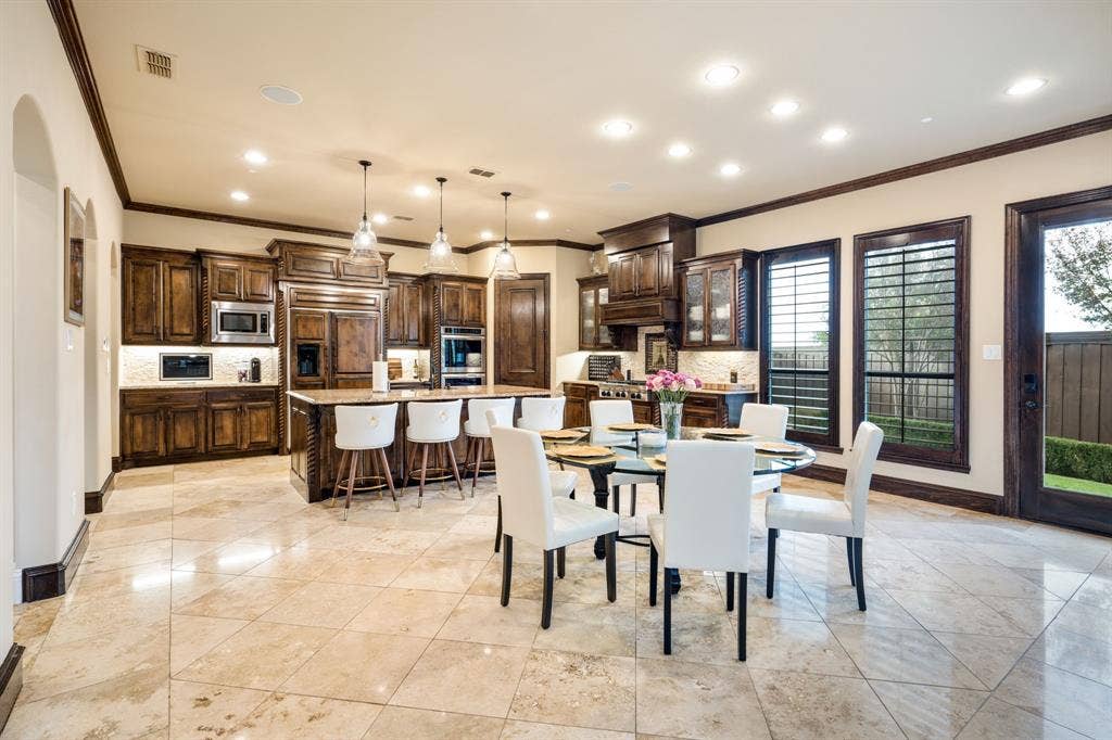 6590 Gerrard Street, Frisco, TX 75034 Kitchen featuring dark wood cabinetry, a central island with stone-finish countertops, tile flooring, recessed lighting, and pendant illumination