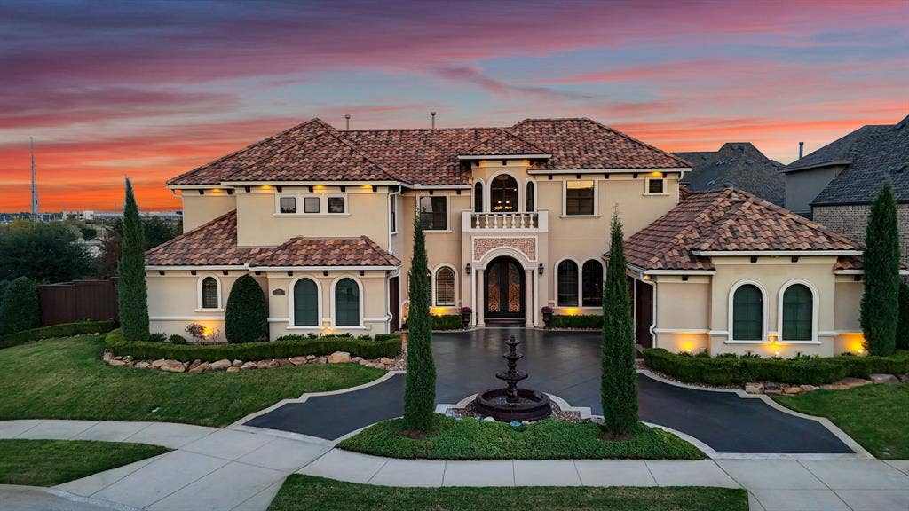 6590 Gerrard Street, Frisco, TX 75034 Stucco exterior featuring a clay tile roof, arched windows, covered balcony, and a circular fountain centered in the paved driveway