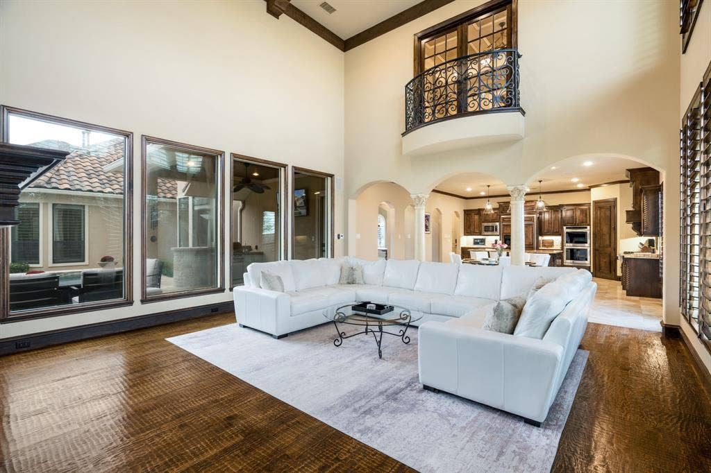 6590 Gerrard Street, Frisco, TX 75034 Vaulted ceilings, expansive floor-to-ceiling windows, arched architectural entries with decorative columns, and an upper-level interior balcony featuring custom wrought-iron railings