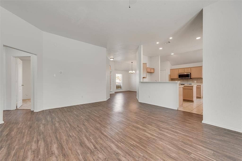 412 Overland Trail, Cedar Hill, TX 75104 Open floor plan featuring wood-finish flooring, recessed lighting, a breakfast bar, and cabinetry with integrated appliances