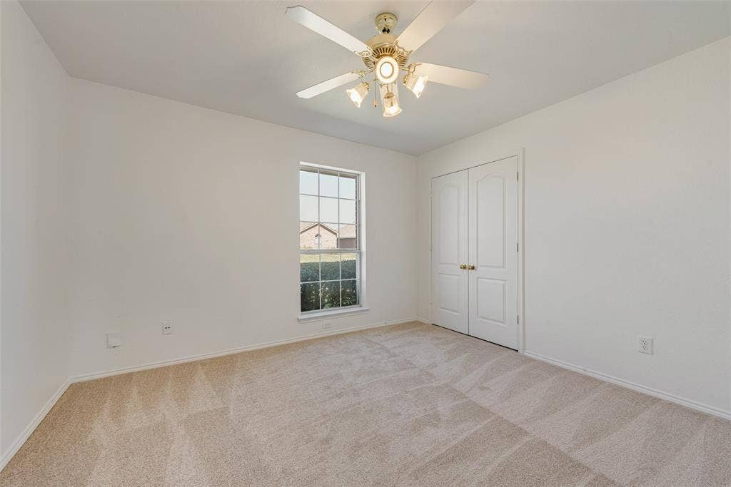 412 Overland Trail, Cedar Hill, TX 75104 Neutral-toned carpeted flooring, multi-pane window, ceiling fan with integrated lighting, and double-panel doors