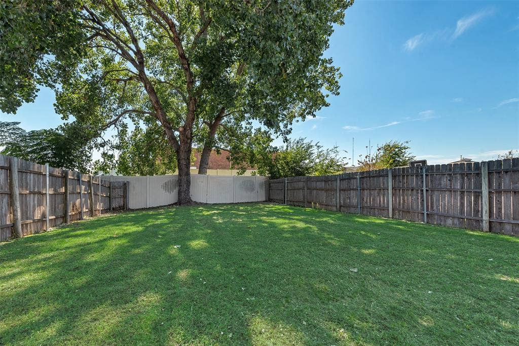 412 Overland Trail, Cedar Hill, TX 75104 Expansive backyard featuring a grass lawn, mature trees, and perimeter wood and vinyl fencing