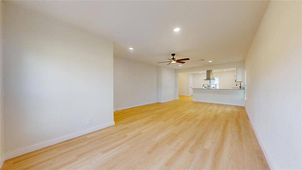 3901 Park Street, Greenville, TX 75401 Open floor plan featuring wood-finish flooring, recessed lighting, ceiling fan, and a breakfast bar with a stainless steel range hood