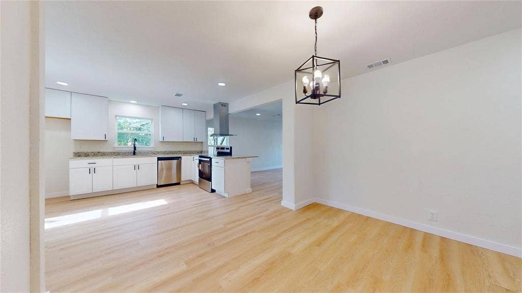 3901 Park Street, Greenville, TX 75401 Kitchen featuring white cabinetry, stone-finish countertops, stainless steel appliances, recessed lighting, and wood-finish flooring with a hanging cage pendant light fixture