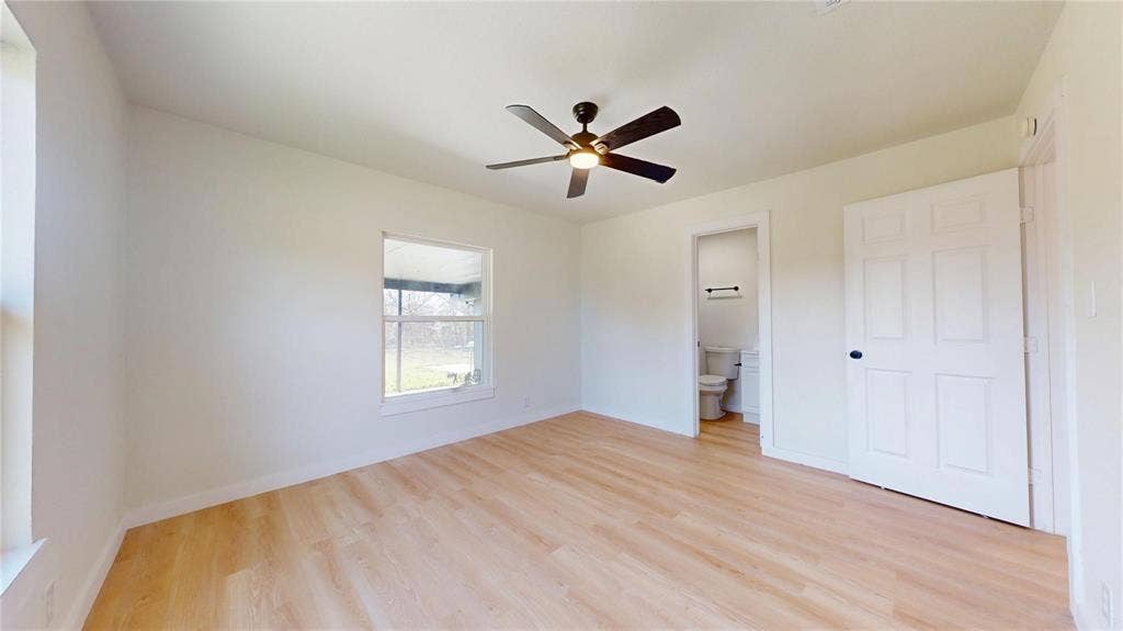 3901 Park Street, Greenville, TX 75401 Interior space featuring light-toned wood-finish flooring, a multi-blade ceiling fan with integrated lighting, and a six-panel door