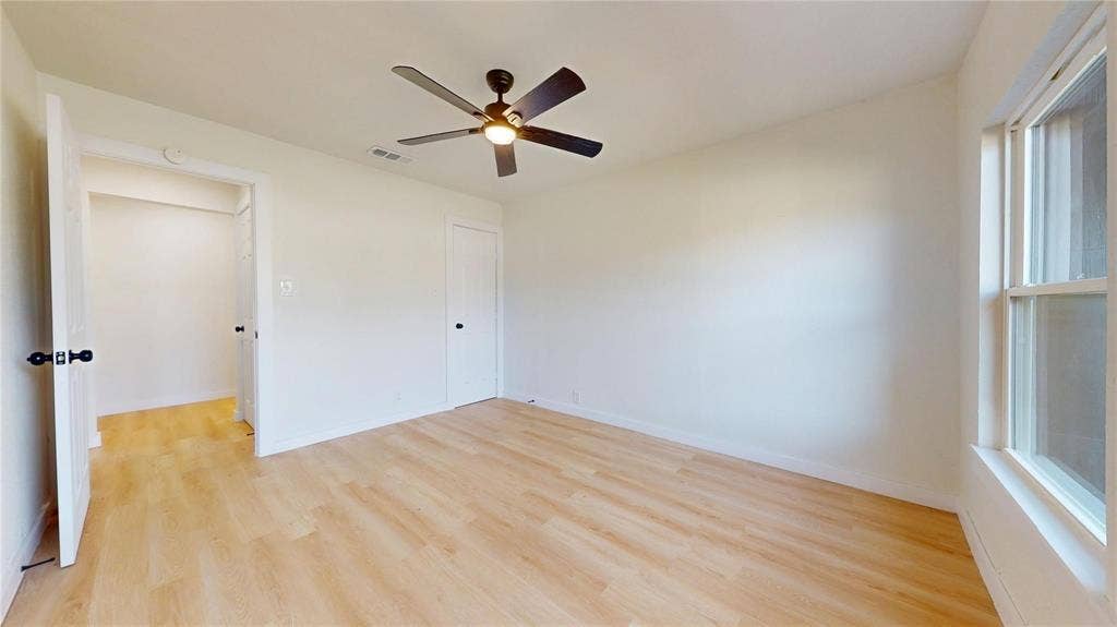 3901 Park Street, Greenville, TX 75401 Neutral-toned interior featuring wood-finish flooring, a five-blade ceiling fan, multi-panel doors, and a double-hung window