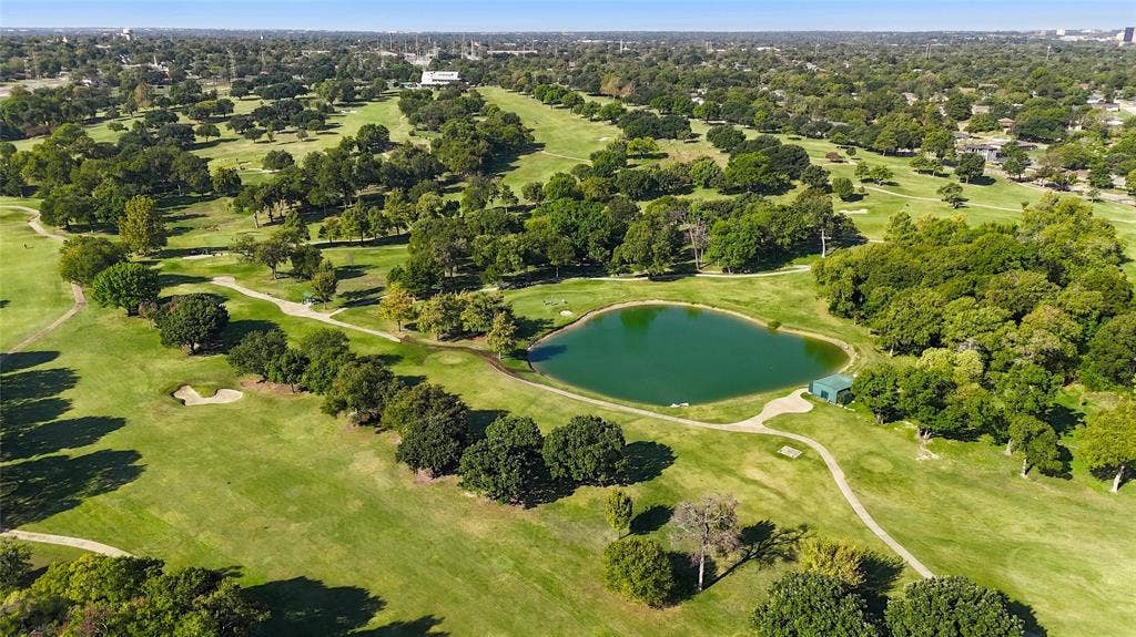 2810 Bonnie View Road, Dallas, TX 75216 Aerial perspective of a golf course featuring expansive green fairways, mature tree canopy, a central pond, and sand bunkers