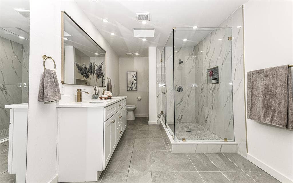 13936 Tanglewood Place, Farmers Branch, TX 75234 The shower is a piece of art work with its glass-enclosure, tiled surround and stone-pattern wall cladding