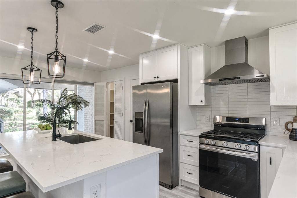 13936 Tanglewood Place, Farmers Branch, TX 75234 Oversized Island with quartz countertop with matte black faucet and gas range is a Chefs dream