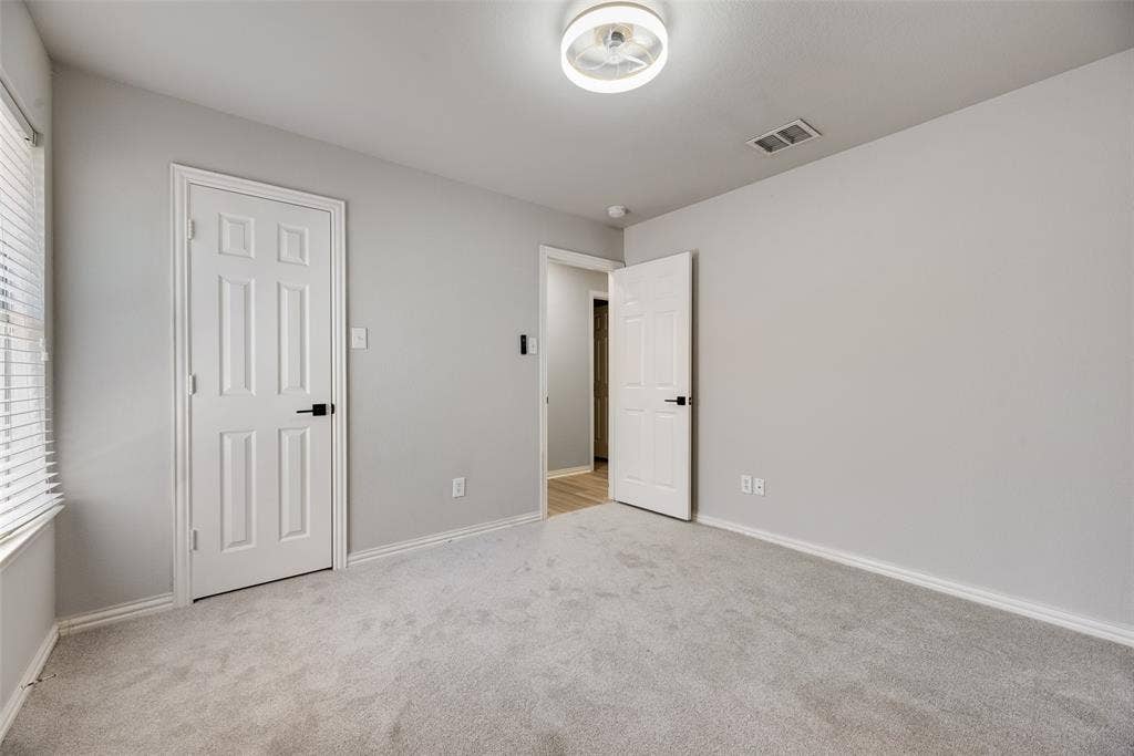 1716 Clarke Springs Drive, Allen, TX 75002 Neutral wall finishes, carpeted flooring, two six-panel interior doors with matte black hardware, and a flush-mount circular LED light fixture
