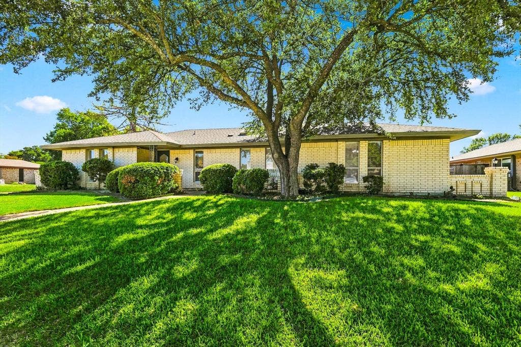 1900 Ports O Call Drive, Plano, TX 75075 Single-story exterior featuring light-toned masonry, a low-profile roofline, mature trees, and manicured landscaping