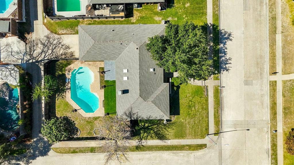 1900 Ports O Call Drive, Plano, TX 75075 Aerial perspective featuring a corner lot, a swimming pool with a concrete deck, a composition shingle roof, and mature trees
