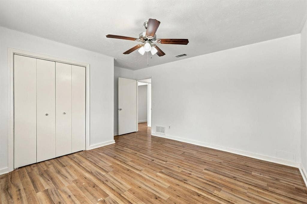 1900 Ports O Call Drive, Plano, TX 75075 Interior room featuring wood-finish flooring, a multi-panel closet, and a ceiling fan with integrated lighting