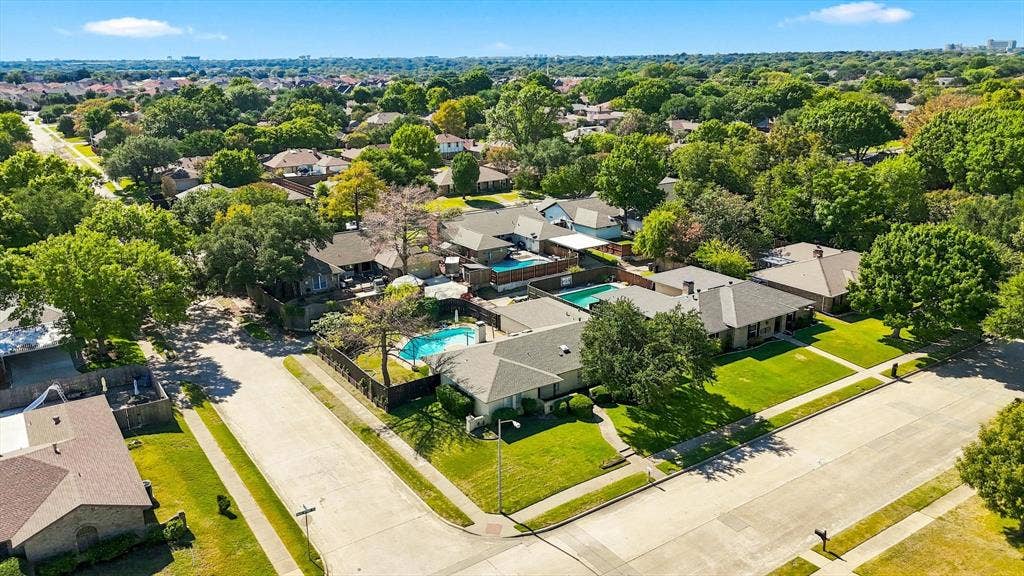1900 Ports O Call Drive, Plano, TX 75075 Aerial perspective of a corner lot property featuring a residential structure, a private swimming pool, mature perimeter landscaping, and asphalt street access