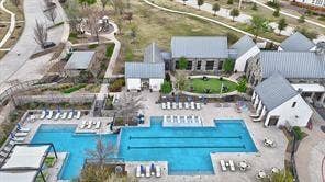15638 Kestrel Mews, Frisco, TX 75035 Multi-structure recreation complex featuring a lap pool with a designated shallow area, hardscaped stone pool deck, and pitched-roof buildings with metal roofing