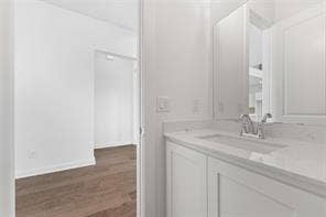 15638 Kestrel Mews, Frisco, TX 75035 White vanity with an integrated basin, light-toned stone countertop, polished chrome faucet, and large rectangular mirror
