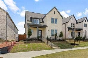 15638 Kestrel Mews, Frisco, TX 75035 Two-story residence featuring a light-toned brick facade, gabled roofline, covered front entryway, and iron-style perimeter fencing
