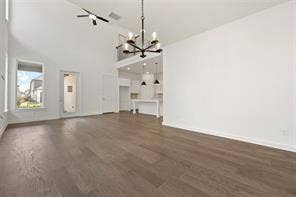 15638 Kestrel Mews, Frisco, TX 75035 Open-concept interior featuring vaulted ceilings, wood-finish flooring, a multi-arm chandelier, and a recessed loft area