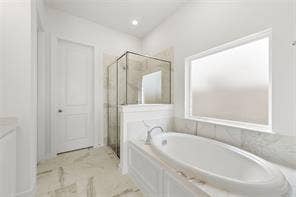 15638 Kestrel Mews, Frisco, TX 75035 Soaking tub with chrome faucet, glass-enclosed shower, stone-finish flooring, and large window with privacy glass