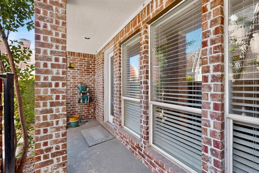 18359 Frankford Lakes Circle, Dallas, TX 75252 Covered exterior patio featuring red brick masonry, recessed lighting, and large windows with integrated blinds