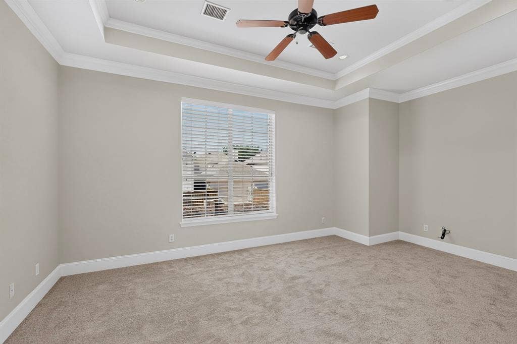 18359 Frankford Lakes Circle, Dallas, TX 75252 Room featuring a tray ceiling, crown molding, wall-to-wall carpeting, and a ceiling fan