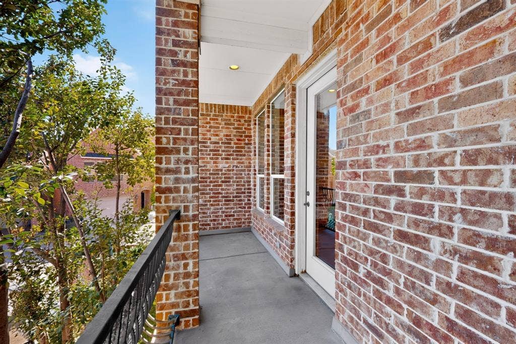 18359 Frankford Lakes Circle, Dallas, TX 75252 Covered balcony featuring exposed brick exterior walls, a concrete floor, recessed lighting, and a metal railing