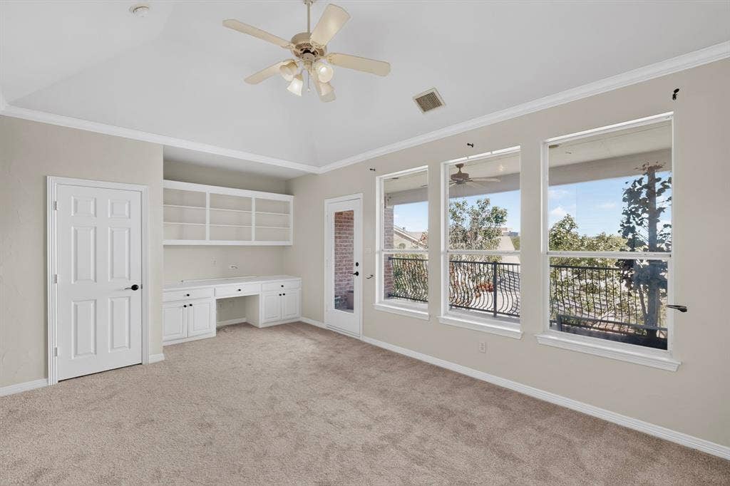 18359 Frankford Lakes Circle, Dallas, TX 75252 Vaulted ceilings, built-in cabinetry with desk space, ceiling fan with integrated lighting, expansive windows, and access to a wrought-iron railed balcony