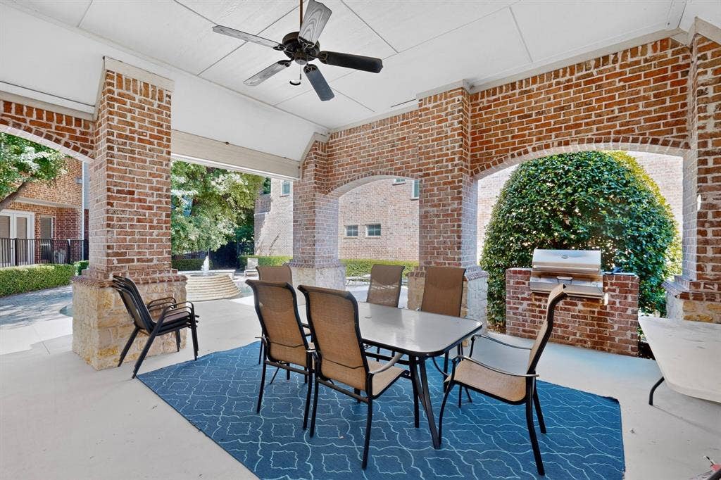 18359 Frankford Lakes Circle, Dallas, TX 75252 Covered patio featuring brick masonry columns with stone bases, integrated stainless steel grill, and ceiling fan