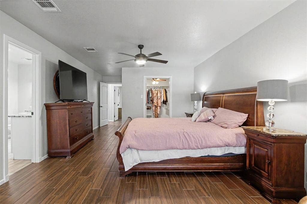 Wood-finish flooring, ceiling fan with integrated lighting, and neutral wall tones