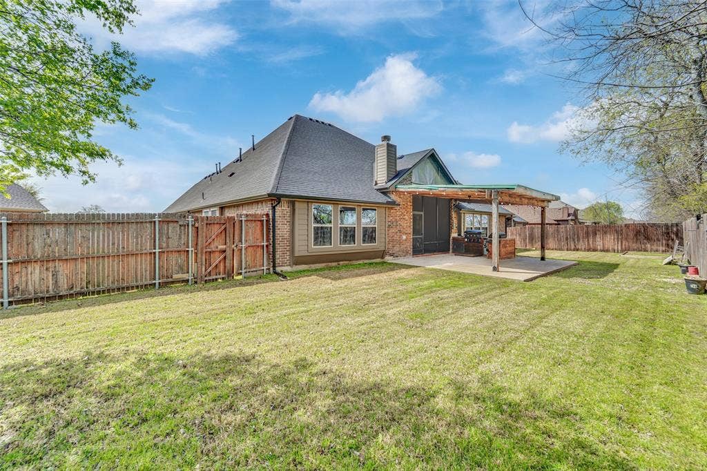 102 Champion Drive, Wylie, TX 75098 Backyard featuring a concrete patio with a covered pergola, brick and siding exterior, and wood privacy fencing