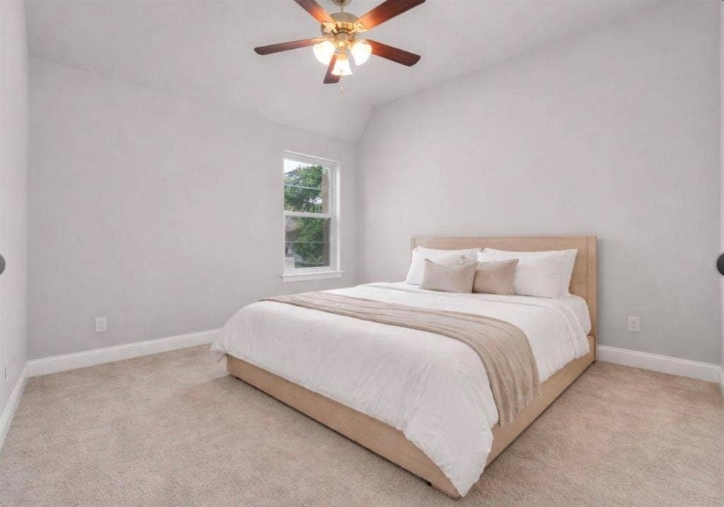 102 Champion Drive, Wylie, TX 75098 Vaulted ceiling, neutral wall tones, plush wall-to-wall carpeting, single-pane window, and a multi-blade ceiling fan with integrated light fixture