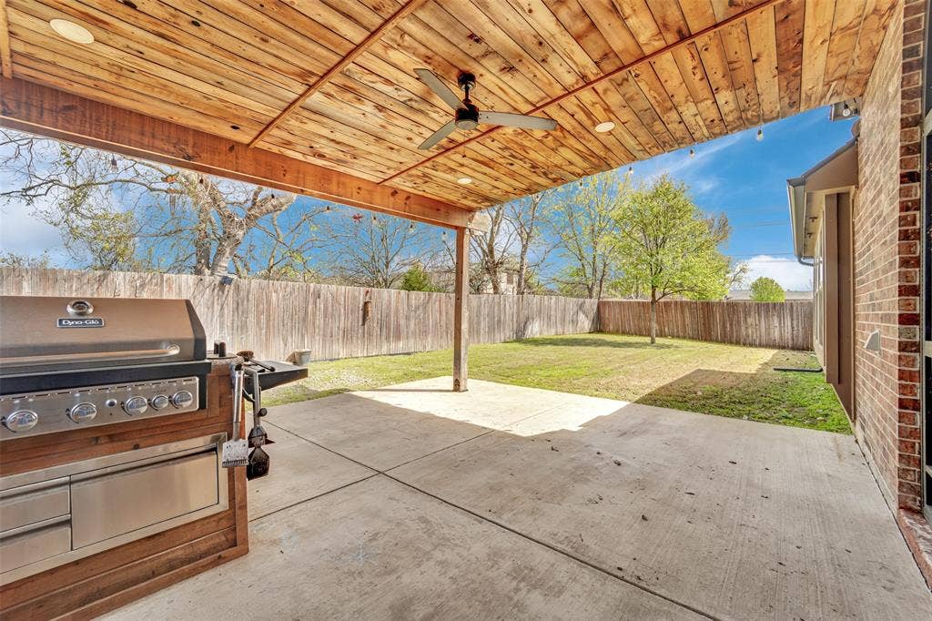 102 Champion Drive, Wylie, TX 75098 Covered patio featuring a wood-plank ceiling, ceiling fan, recessed lighting, integrated stainless steel grill, and concrete flooring