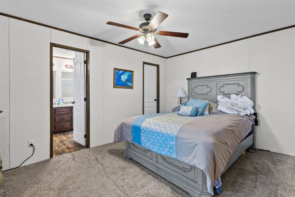 Room featuring wall-to-wall carpeting, wood-trim detailing, and a ceiling fan with integrated lighting