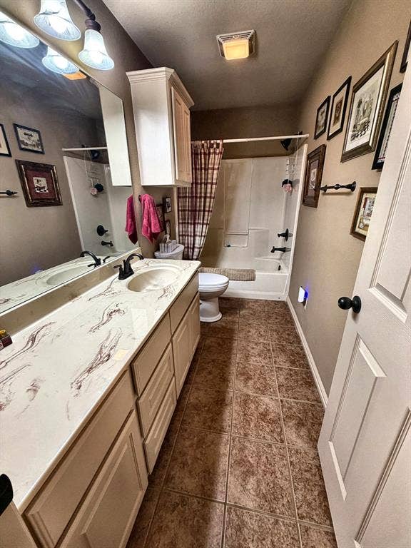 9031 Mallard Way, Larue, TX 75770 Bathroom featuring a vanity with patterned countertop, integrated oval sink, matte black hardware, and wall-to-wall vanity mirror, paired with a shower-tub combination and tile-finish flooring
