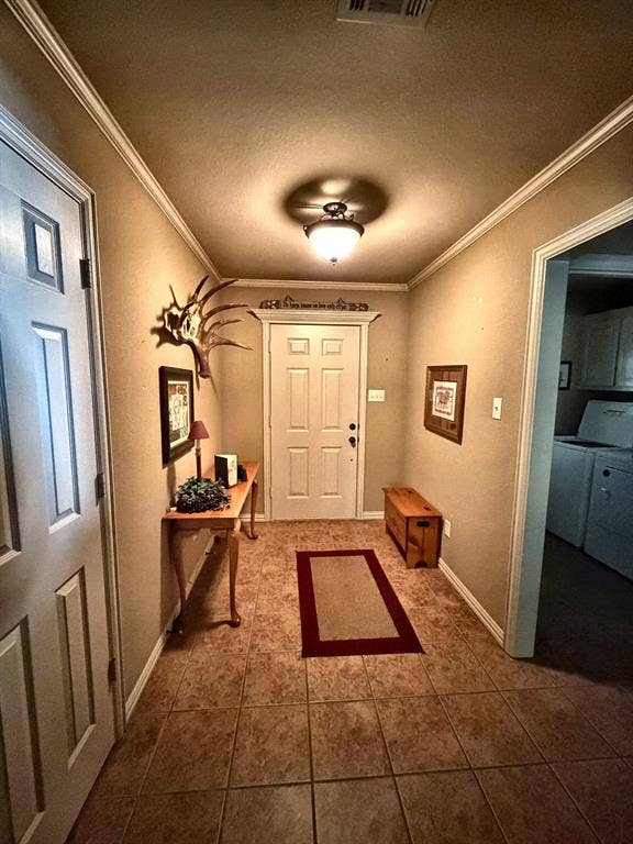9031 Mallard Way, Larue, TX 75770 Entryway featuring six-panel door with architectural molding, neutral tile flooring, crown molding, and semi-flush mount dome lighting