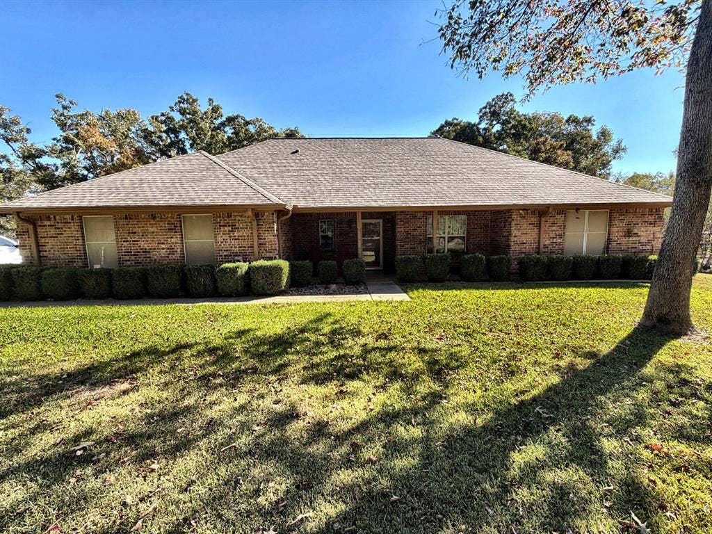 9031 Mallard Way, Larue, TX 75770 Single-story brick exterior featuring a hipped roofline, symmetrical window placement, and manicured shrubbery