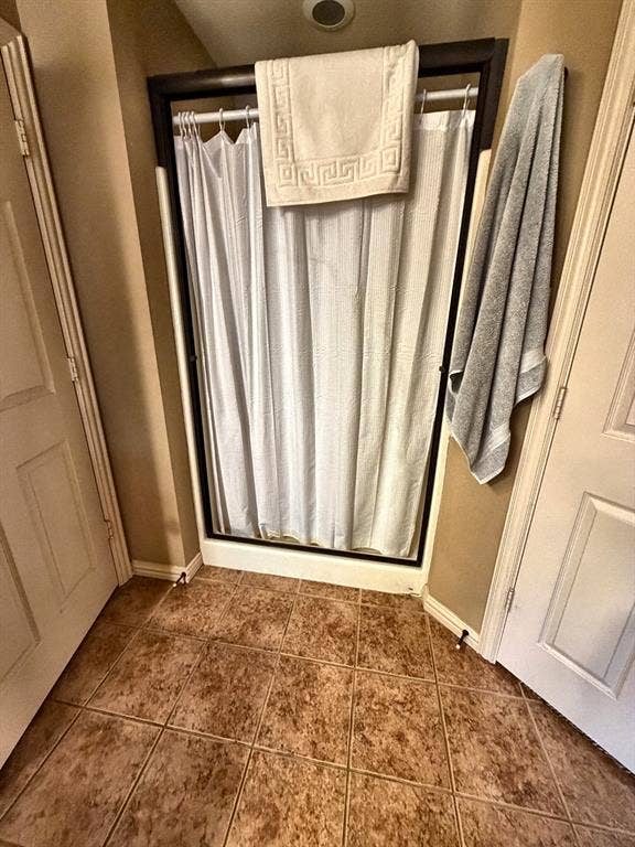 9031 Mallard Way, Larue, TX 75770 Shower enclosure featuring a dark frame, white tile flooring, and two paneled interior doors