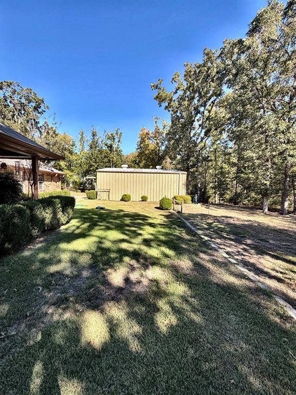9031 Mallard Way, Larue, TX 75770 Expansive backyard featuring a metal detached structure, mature trees, and landscaping