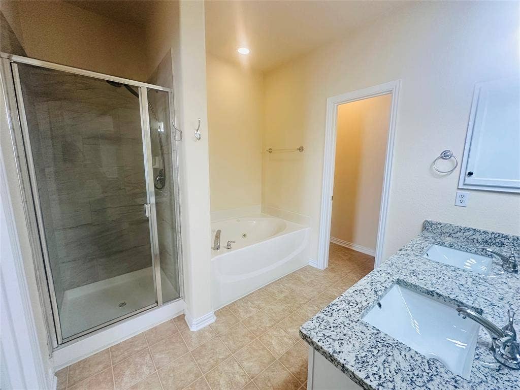 Bathroom featuring vanity, independent shower and bath, and tile patterned flooring