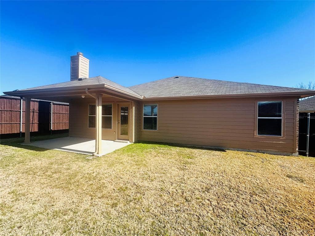 Rear view of house featuring a yard and a patio
