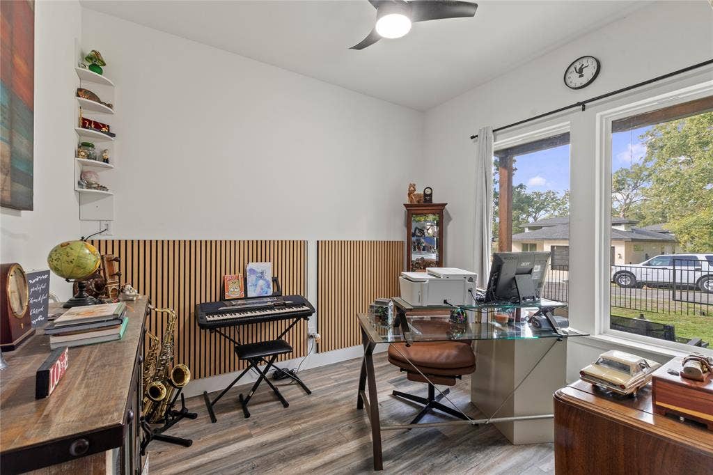 6113 Ottawa Trail, Mabank, TX 75156 Wood-finish flooring, vertical slat wall paneling, built-in corner shelving, recessed ceiling fan with integrated lighting, and expansive windows