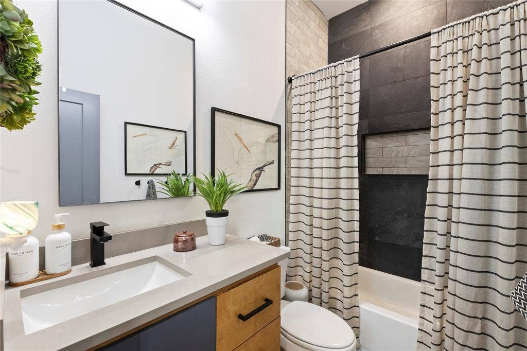 6113 Ottawa Trail, Mabank, TX 75156 Modern vanity with a light-toned solid surface countertop, matte black faucet, rectangular undermount sink, and dual-tone cabinetry featuring black hardware