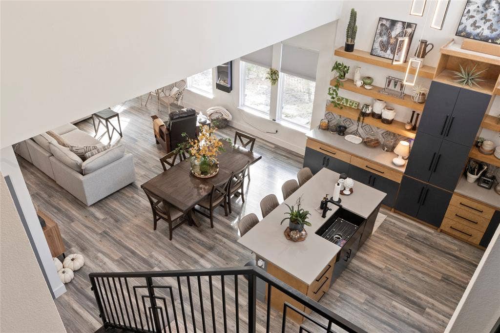 6113 Ottawa Trail, Mabank, TX 75156 Open-concept interior featuring two-story ceilings, wood-finish flooring, and a kitchen island with a rectangular basin sink and matte black hardware
