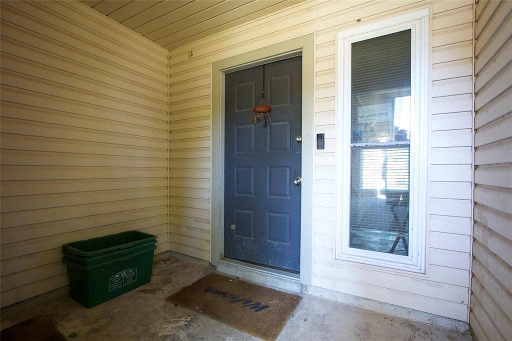 626 Thornwood Trail, Grand Prairie, TX 75052 Covered entryway featuring horizontal siding, a six-panel dark gray door, and a full-length sidelight window