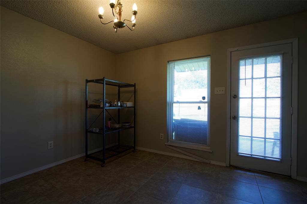 626 Thornwood Trail, Grand Prairie, TX 75052 Multi-pane glass-panel exterior door, neutral tile flooring, and overhead multi-arm chandelier lighting