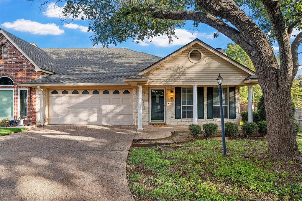 201 Pecan Village Circle, Waco, TX 76710 Exterior facade featuring mixed stone and horizontal siding, arched window detail, covered front porch with columns, and a textured concrete driveway