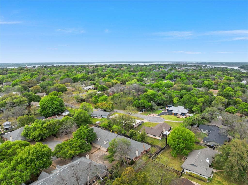 201 Pecan Village Circle, Waco, TX 76710 Aerial perspective of a suburban neighborhood featuring mature trees, paved roadways, and residential structures with shingled roofing