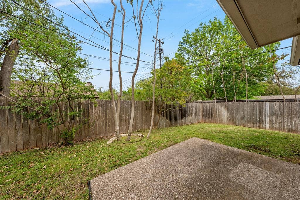 201 Pecan Village Circle, Waco, TX 76710 Backyard featuring a concrete patio, wood privacy fencing, and mature trees